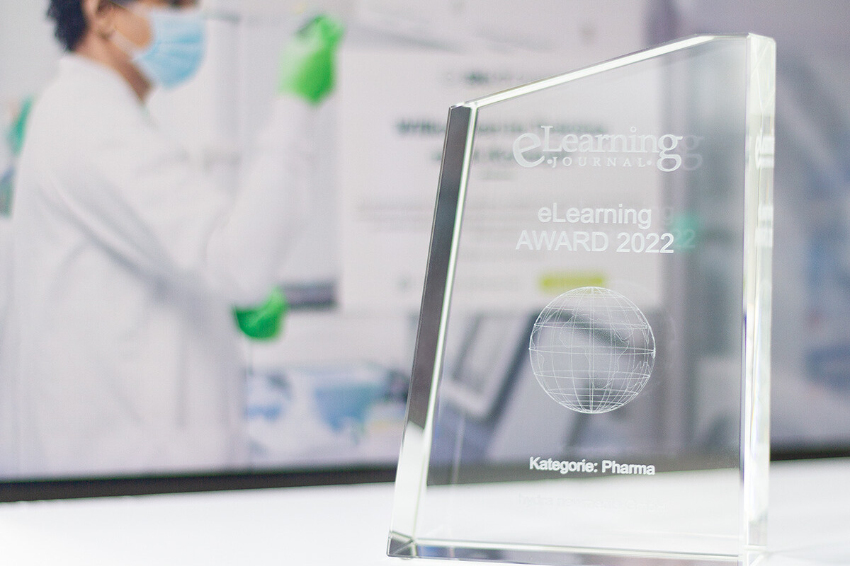 eLearning AWARD 2022 in der Kategorie Pharma, dahinter Visual aus dem BioNTech WBT des E-Learning Anbieters hydra